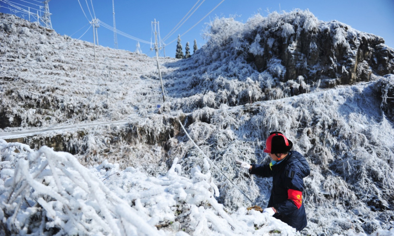 2018年1月9日，務(wù)川供電局工作人員在貴州務(wù)川仡佬族苗族自治縣石朝鄉(xiāng)觀測覆冰厚度。（新華社記者 陶亮 攝）