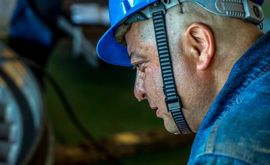 紅雁池電廠#3機組小修現場，一名焊工剛剛取下面罩，鼻尖上的汗珠上映射出手里的面罩。（作者：甄新梅）