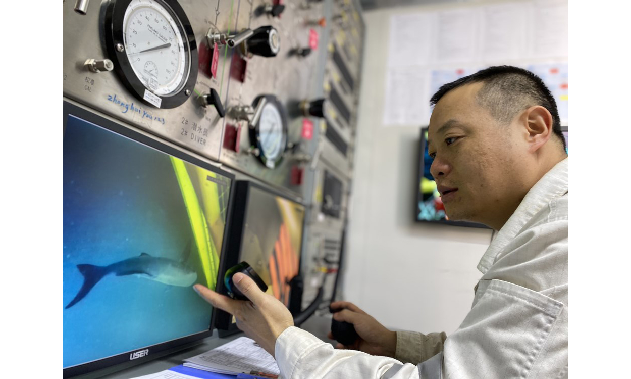 “十三五”期間，擁有最大一支“海油蛙人”團(tuán)隊(duì)的海洋石油工程股份有限公司技術(shù)服務(wù)分公司通過科研攻關(guān)、升級改造設(shè)備等舉措打造綠色海洋技術(shù)服務(wù)體系，在做好海洋能源開發(fā)者的同時擔(dān)起海洋環(huán)境保護(hù)者的責(zé)任。過去5年，該公司完成5個項(xiàng)目的單點(diǎn)及導(dǎo)管架平臺拆除，總重量近6000噸；完成水下雜物清理約1176噸；通過引進(jìn)、推廣綠色清潔無損檢測高新技術(shù)，守護(hù)藍(lán)色海洋。圖為海上液化天然氣接收站項(xiàng)目水下作業(yè)過程中，監(jiān)控顯示一條大魚前來“圍觀”潛水員作業(yè)。