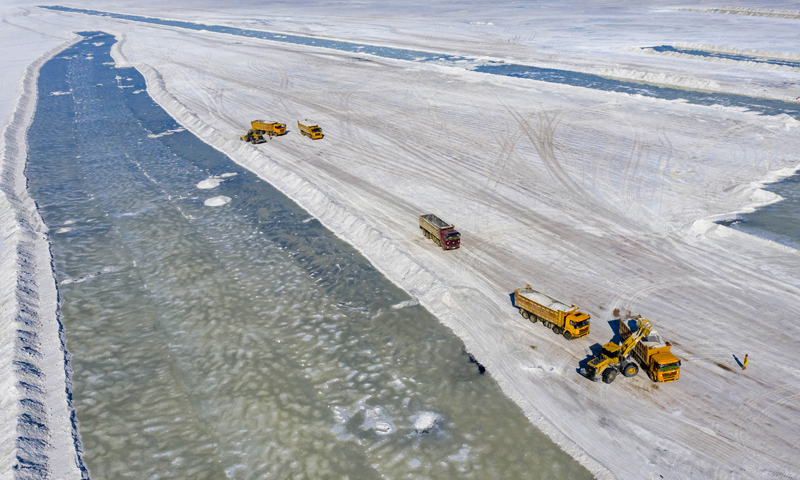 圖為6月21日，在新疆和布克賽爾蒙古自治縣瑪納斯鹽湖，運(yùn)輸車輛在裝載原料鹽。（新華社記者 胡虎虎 攝）