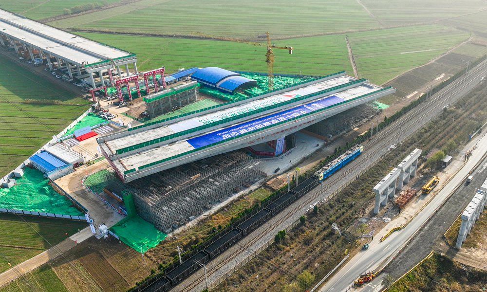 跨京滬鐵路轉體橋上部結構采用預應力混凝土T構，跨徑組合為（68+68）米，下部結構主墩采用“V”型空心墩設計，整幅橋梁全寬38.33米，轉體重量高達25680噸，主承臺深基坑開挖處臨近繁忙干線京滬鐵路，距路基坡腳線最近處僅有15米，臨近鐵路基坑開挖深度10余米，施工過程復雜、精度要求高。圖為轉體橋轉體中。