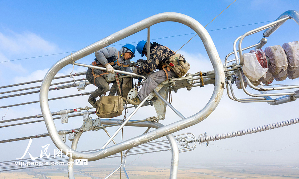 2022年11月23日，在1000千伏特高壓盱眙至泰州線路升高改造工程現(xiàn)場，江蘇省送變電有限公司施工人員正在百米高空架設(shè)導(dǎo)線。本次升高改造共組立新鐵塔4基，拆除舊鐵塔3基，將輸電線路對地安全距離由原來的19米提高至30米，保障阜興泰高速公路建成后車輛通行安全。同時(shí)，將進(jìn)一步提高電網(wǎng)可靠性，確保迎峰度冬期間電網(wǎng)安全供電。史俊 攝