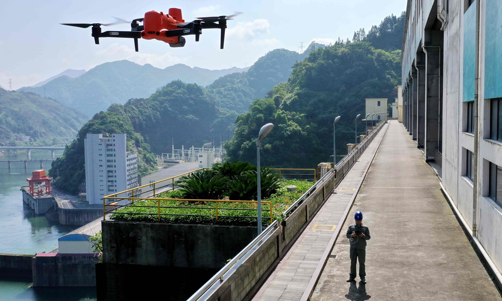 近日，國家電網湖南水電公司員工操作無人機巡查柘溪電廠水工建筑物，確保汛期設備安全。