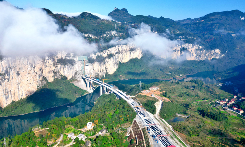 11月29日零時18分，由中國鐵建旗下昆侖集團參與投資、鐵一院勘察設(shè)計、中鐵二十局承建的渝湘復(fù)線高速控制性工程——阿蓬江大橋?qū)崿F(xiàn)雙幅順利合龍，標(biāo)志著渝湘復(fù)線高速彭酉段建設(shè)進入沖刺收尾階段，為全線通車奠定了堅實基礎(chǔ)。圖為阿蓬江大橋施工現(xiàn)場航拍。