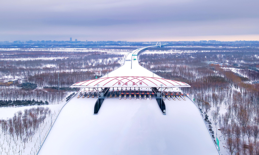 12月28日10時，京雄高速公路（北京段）正式通車運營，并與既有京雄高速河北段相連接，至此京雄高速公路全線順利貫通，從北京西南五環駕車至雄安新區實現了1小時內通達。圖為雪景下的京雄高速公路。