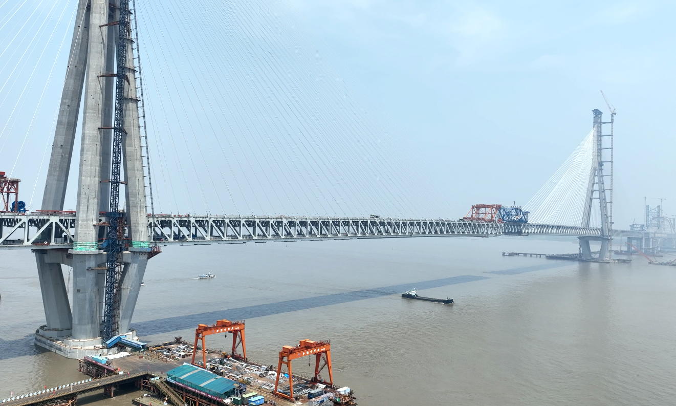 常泰長江大橋跨度大、荷載能力要求高，鋼結(jié)構(gòu)制造精度要求極為嚴(yán)格，以確保橋梁的穩(wěn)固和安全。中鐵工業(yè)旗下中鐵山橋依托常泰長江大橋構(gòu)建了以板材智能下料切割生產(chǎn)線、車間制造執(zhí)行智能管控系統(tǒng)等為核心的“五線一系統(tǒng)”鋼橋智造新模式，全面提升鋼桁梁制造的自動化、數(shù)字化、網(wǎng)絡(luò)化、智能化水平，同時(shí)應(yīng)用大型雙三維龍門數(shù)控鉆床等設(shè)備，將桁梁桿件極邊孔距偏差控制在1毫米范圍內(nèi)，確保橋梁以毫米級精度合龍。