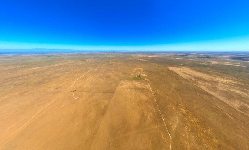 在光伏基地建設之前，大片荒地裸露在外，國電電力內(nèi)蒙古綜合能源的建設者們扎根于此，在茫茫荒原上用青春和熱血澆灌出一片令人驚嘆的“光伏藍海”。圖為2023年9月拍攝的項目選址原始地貌。