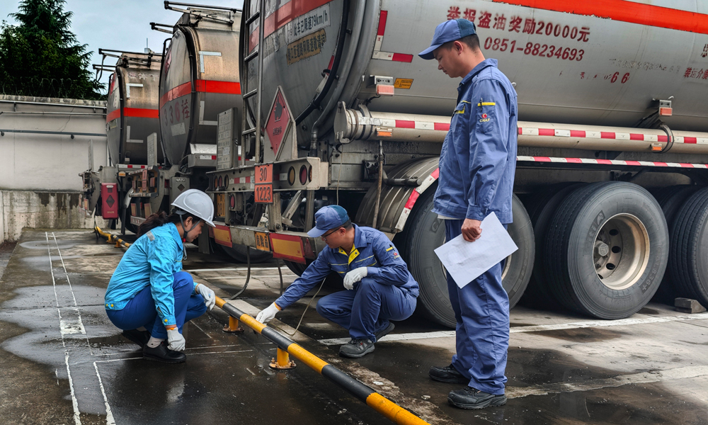 中國(guó)航油貴州分公司業(yè)務(wù)油庫(kù)員工檢查運(yùn)油車完好性。