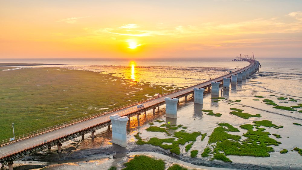 落日熔金，蜿蜒的橋墩如長龍靜臥杭州灣。目前，中交二航局參建的世界最長鐵路跨海橋梁——杭州灣跨海鐵路大橋樁基基礎(chǔ)施工已完成，正全面轉(zhuǎn)入塔柱施工、箱梁架設(shè)等上部結(jié)構(gòu)施工階段。