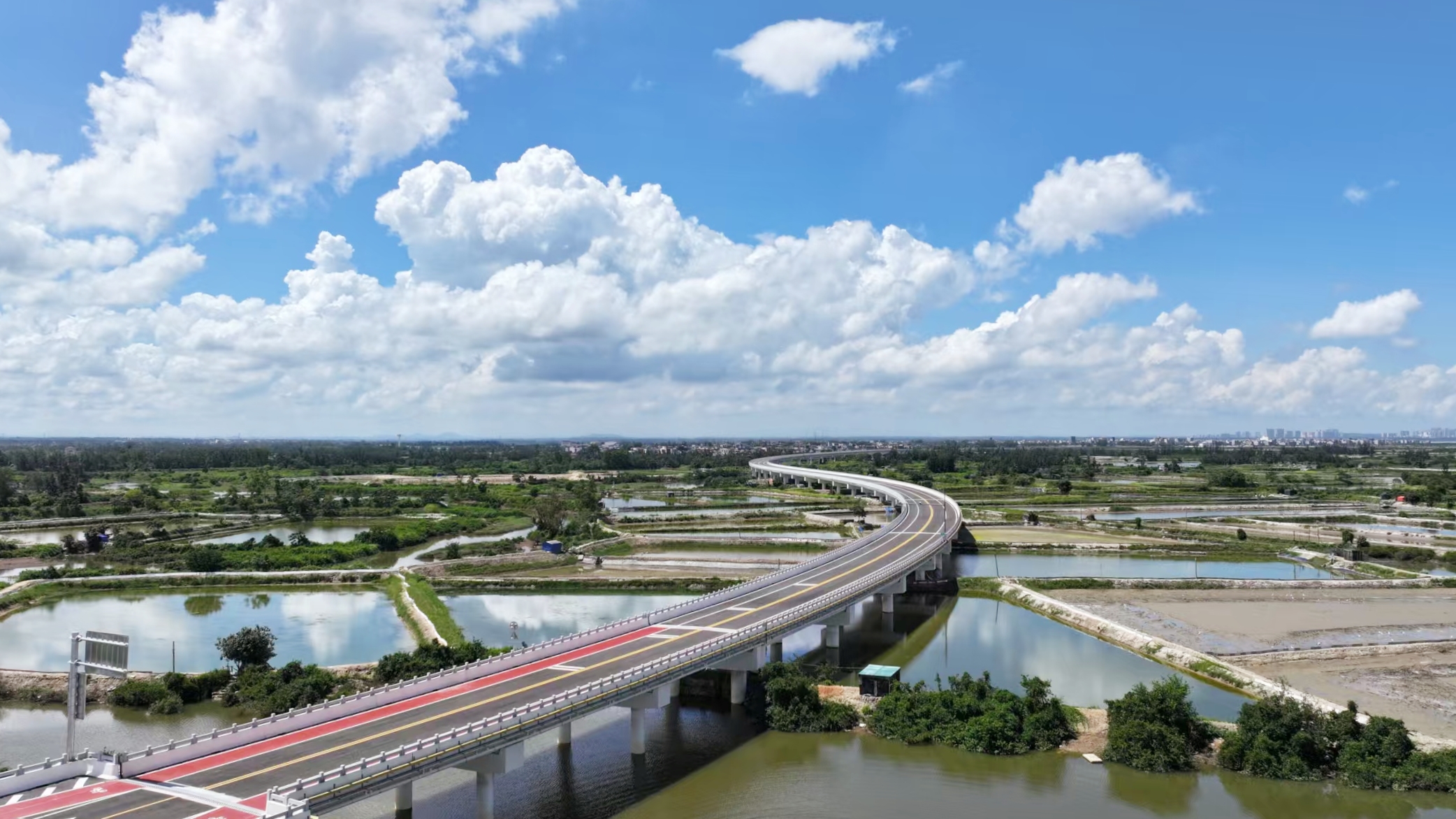 中鐵二局承建的北門江特大橋是環新英灣支線的控制性工程，全長2074米，設計時速60公里。該橋位于海灣和紅樹林自然保護區內，項目部嚴格遵循“生態優先、綠色施工”理念，橋面采用防滑耐磨環保材料，實現施工廢水、揚塵100%達標處理，確保工程建設與濱海生態和諧共生。