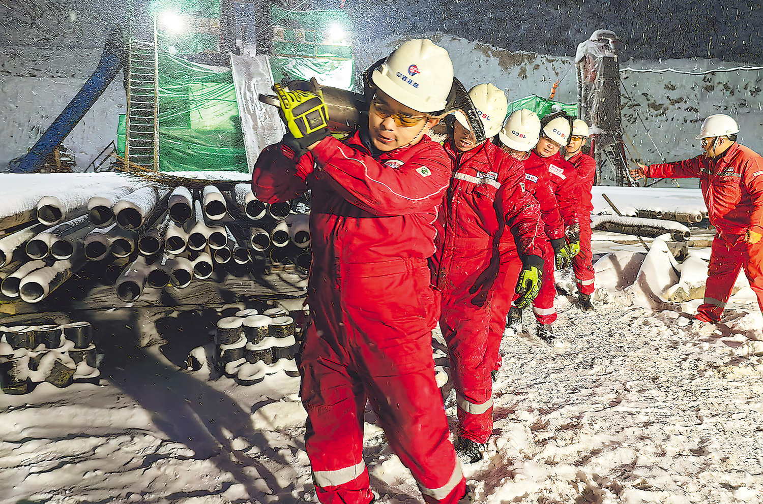 寒夜中，山西臨興氣田區塊測井隊員搬運測井設備。