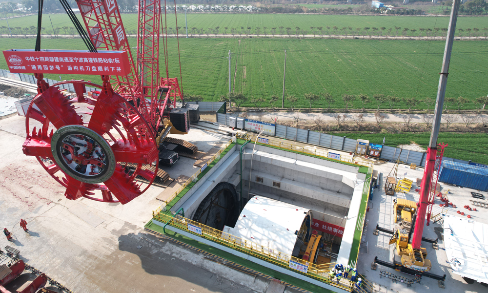 “通甬園夢號”盾構(gòu)機(jī)搭載的“推拼同步+同步雙液注漿+整體式全預(yù)制箱涵同步拼裝”成套先進(jìn)技術(shù)，在國內(nèi)超大直徑盾構(gòu)設(shè)備中尚屬首次應(yīng)用，將全面提升盾構(gòu)施工安全、施工效率和成型隧道質(zhì)量。圖為刀盤吊裝現(xiàn)場。