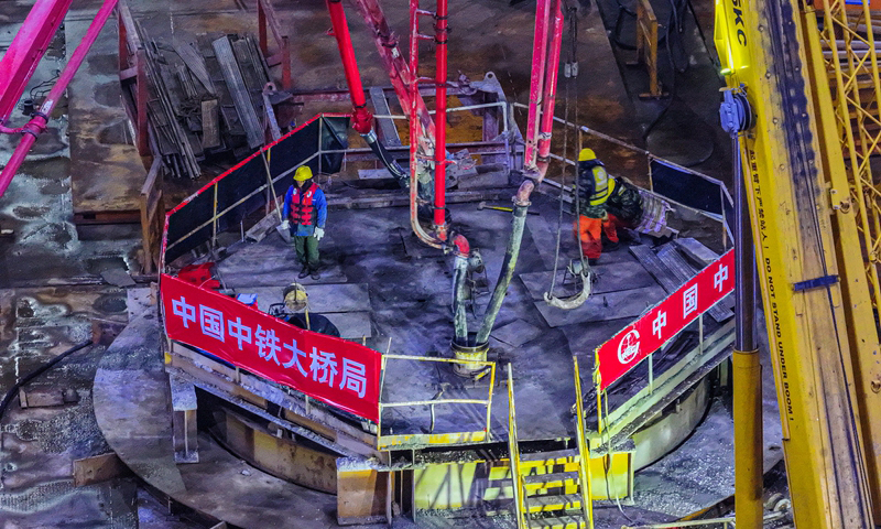 1月7日，位于浙江省舟山市的甬舟鐵路西堠門公鐵兩用大橋5號主墩超大直徑鉆孔樁灌注施工全部完成，大橋建設迎來階段性勝利。據了解，西堠門公鐵兩用大橋5號主墩由18根直徑6.3米鉆孔灌注樁組成。西堠門公鐵兩用大橋全長3118米，主橋主跨達1488米。圖為當日清晨，甬舟鐵路西堠門公鐵兩用大橋5號主墩超大直徑鉆孔樁灌注施工現場，工人在澆筑最后一根鉆孔樁（無人機照片）。新華社發（姚峰?攝）