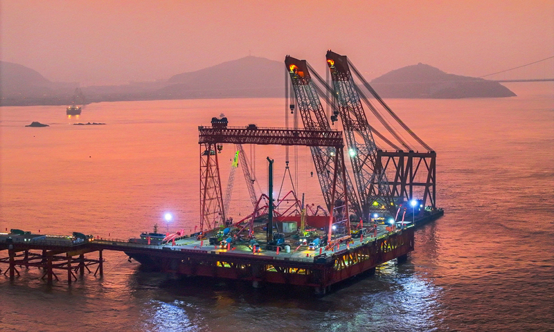 1月7日清晨，甬舟鐵路西堠門公鐵兩用大橋5號主墩超大直徑鉆孔樁灌注施工現場，工人在澆筑最后一根鉆孔樁（無人機照片）。新華社發（姚峰?攝）