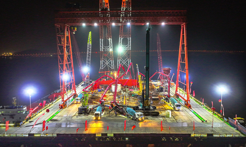 1月7日清晨，甬舟鐵路西堠門公鐵兩用大橋5號主墩超大直徑鉆孔樁灌注施工現場，工人在澆筑最后一根鉆孔樁（無人機照片）。新華社發（姚峰?攝）