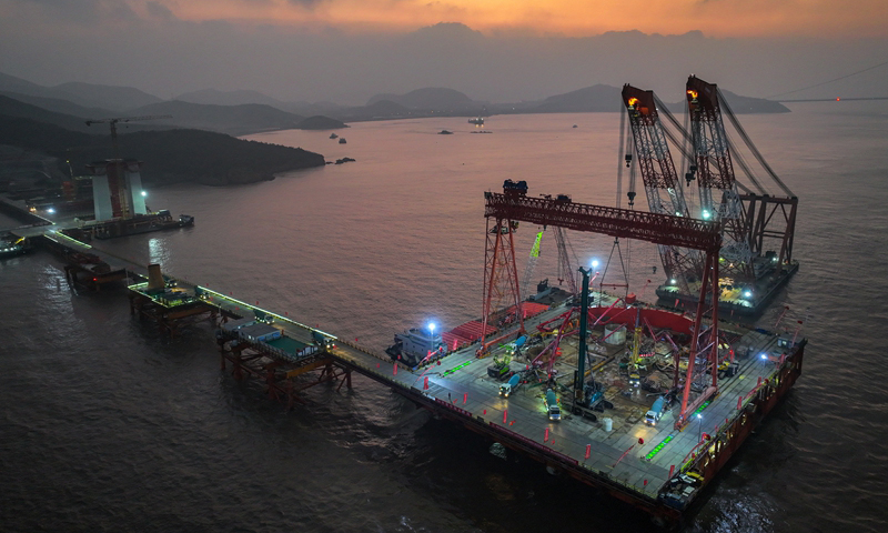 1月7日清晨，甬舟鐵路西堠門公鐵兩用大橋5號主墩超大直徑鉆孔樁灌注施工現場，工人在澆筑最后一根鉆孔樁（無人機照片）。新華社發（姚峰?攝）