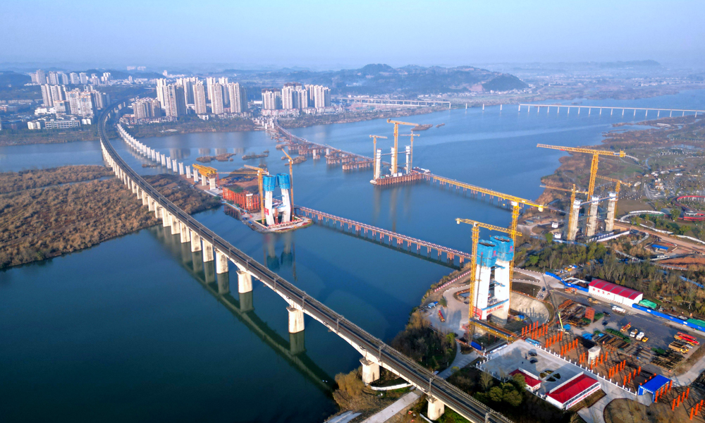 圖為中鐵十七局參與建設的“西南第一橋”——成達萬高速鐵路涪江特大橋。目前，主橋中塔柱施工和主橋邊跨現澆支架搭設正在全面推進，建設團隊對主塔高空作業安全設備進行專項檢查，同時創新應用工藝工法，搭建智慧工地平臺，高質量、高效率加快進度，全力打造精品工程和綠色工程。項目建成后將實現350萬遂寧人民進入“高鐵時代”的愿望，助力成渝地區雙城經濟圈建設。