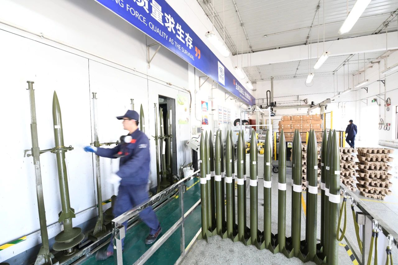 走進(jìn)航天科技四院中天火箭公司人影火箭科研生產(chǎn)基地，巍峨的遠(yuǎn)山與基地內(nèi)規(guī)劃有序的樹木、道路及干凈的藍(lán)白色廠房相映成趣。在這家以“服務(wù)氣象 保護(hù)生態(tài) 守護(hù)綠水青山”為使命的航天企業(yè)，人影火箭均采用環(huán)保材料制造，生產(chǎn)過程綠色無害，回收利用綠色環(huán)保；稱裝藥、噴漆包裝、總裝等重點(diǎn)生產(chǎn)環(huán)節(jié)已實(shí)現(xiàn)自動(dòng)化、信息化，生產(chǎn)方式低碳轉(zhuǎn)型成效顯著。圖為中天火箭公司人影火箭生產(chǎn)現(xiàn)場。