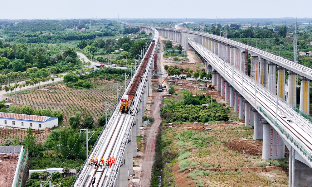 日前，隨著最后一對500米長鋼軌平穩(wěn)鋪設(shè)在無砟道床上，標(biāo)志著由中國鐵建旗下中鐵十二局參與建設(shè)的新建荊門至荊州高鐵（以下簡稱：荊荊高鐵）全線鋪軌順利完成，為年內(nèi)實(shí)現(xiàn)開通運(yùn)營奠定了堅(jiān)實(shí)基礎(chǔ)。圖為鋪軌作業(yè)現(xiàn)場。