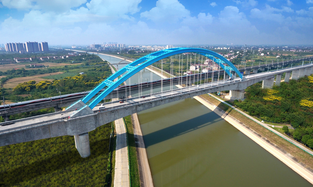荊荊高鐵自荊門西站起，途經(jīng)荊門、沙洋、荊州等縣（市），終點(diǎn)與荊州站接軌，全長77.6公里，設(shè)計(jì)時(shí)速350公里。中鐵十二局承擔(dān)了線路343孔箱梁架設(shè)以及全線151.18公里的鋪軌任務(wù)。圖為荊荊高鐵漢江運(yùn)河特大橋。