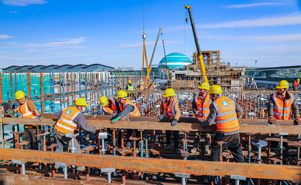 哈薩克斯坦阿斯塔納輕軌項目，是中亞地區(qū)第一條城市輕軌線路，也是中亞地區(qū)第一條全部采用中國標準和中國裝備建造的軌道交通項目。該項目全長約22.4公里，中國建筑旗下中建六局承建了其中的18.34公里，共14個車站、15個區(qū)間及1個車輛段。目前，項目建設(shè)正在穩(wěn)步推進中。圖為中方建設(shè)者在努爾蘇丹國際機場附近的建設(shè)區(qū)間進行現(xiàn)澆梁支架主龍骨安裝作業(yè)。