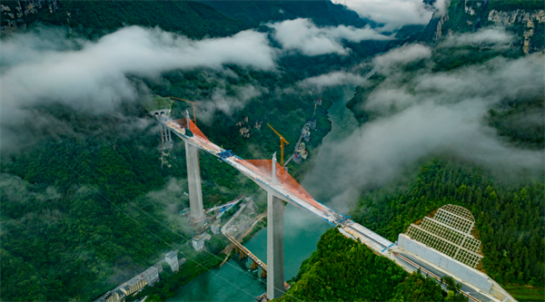 據統計，磨寨烏江特大橋共澆筑混凝土約15萬立方米，安裝鋼筋約2.2萬噸，需要分成37個5到6米的小節段，一節一節多個循環施工。項目建設團隊量身定制了一套超高墩、大截面、重型全封閉智能液壓爬模系統，將各個作業面的位移值、位移差值、液壓系統壓力值以及風速值清晰集成于控制柜的顯示屏上，施工人員可以遠程監控模架運行數據及實時運行情況，通過指尖完成全套操作。在智能化、數字化的系統幫助下，大橋一天可以“長高”1米多，比傳統手動機械系統效率高25%。