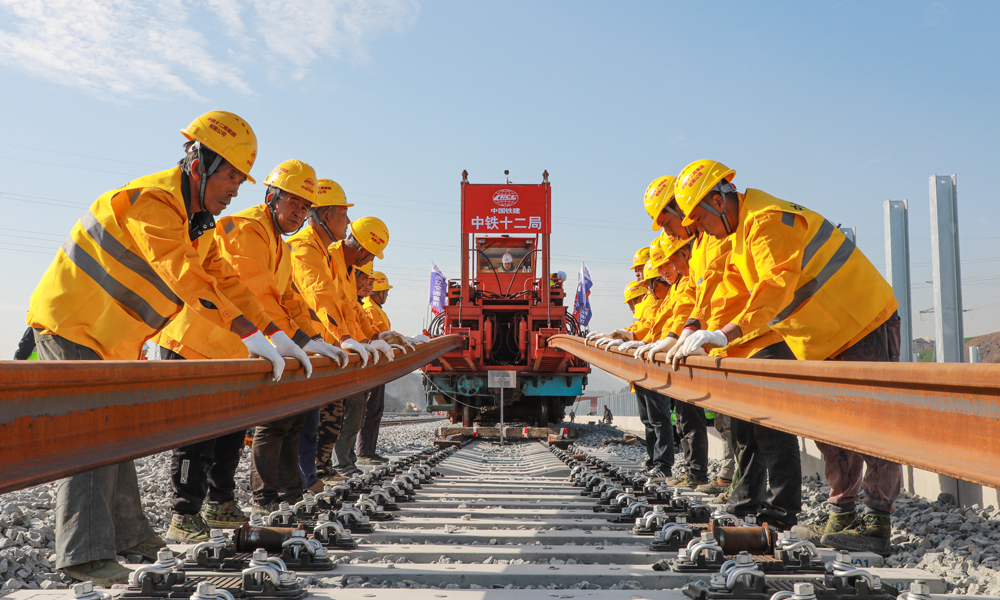 杭溫高鐵建成運營后，杭州、金華、臺州、溫州等地的仙華山、仙居、楠溪江等豐富的旅游資源將串聯(lián)成線，沿線仙居、磐安、東陽、浦江等地將正式邁入高鐵時代，對于推進(jìn)鐵路基礎(chǔ)設(shè)施聯(lián)網(wǎng)、補網(wǎng)、強鏈，打造“軌道上的長三角”，構(gòu)建浙江省“1小時交通圈”，便利沿線人民群眾出行，促進(jìn)旅游資源開發(fā)和產(chǎn)業(yè)發(fā)展，助力浙江高質(zhì)量發(fā)展建設(shè)共同富裕示范區(qū)和長三角一體化高質(zhì)量發(fā)展等具有重要意義。圖為鋪軌機作業(yè)施工現(xiàn)場。