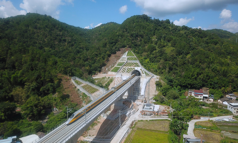 近日，由中國(guó)鐵建旗下中鐵十二局、中鐵二十五局等單位參建的龍龍高鐵梅龍段（梅州西至龍川西段）進(jìn)入試運(yùn)行階段。圖為列車駛出龍龍高鐵梅龍段何公塘隧道。