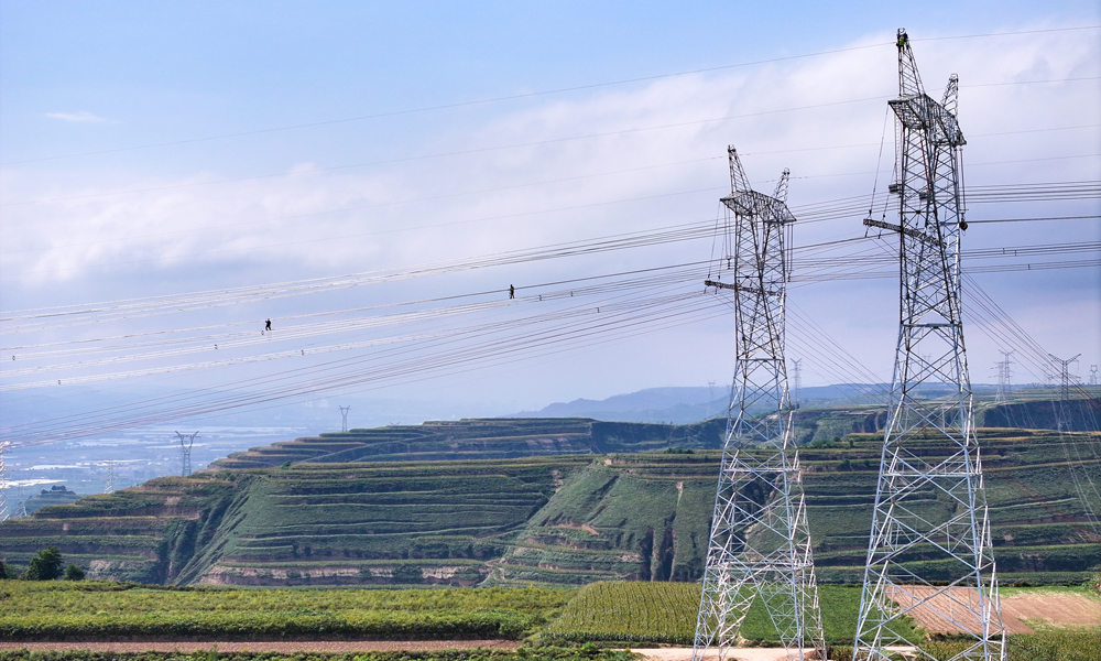 國家電網甘肅送變電公司施工人員在750千伏隴東換流站接入工程跨越330千伏崆塬Ⅰ線工程現場架設導線。