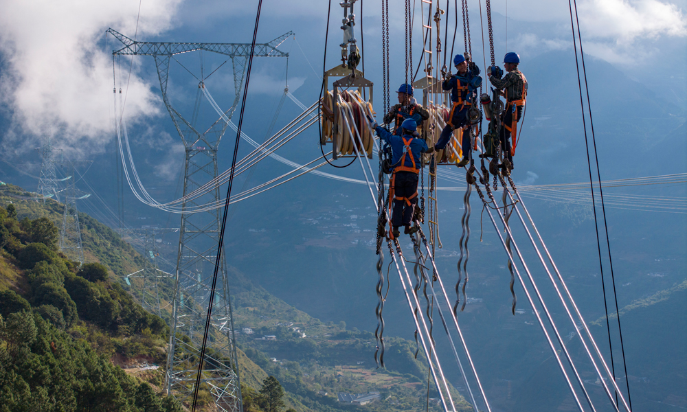 施工人員在川渝1000千伏特高壓交流工程8標段處進行收緊導線作業(yè)。