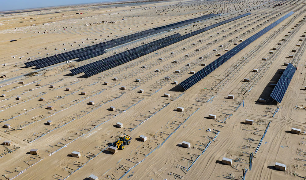 近日，塔克拉瑪干沙漠北緣，庫爾勒市以西65千米處，上庫高新區低碳轉型130萬千瓦光伏項目建設現場，工作人員在為光伏面板安裝支架。四周已經立起的支架一排排向遠方延伸。