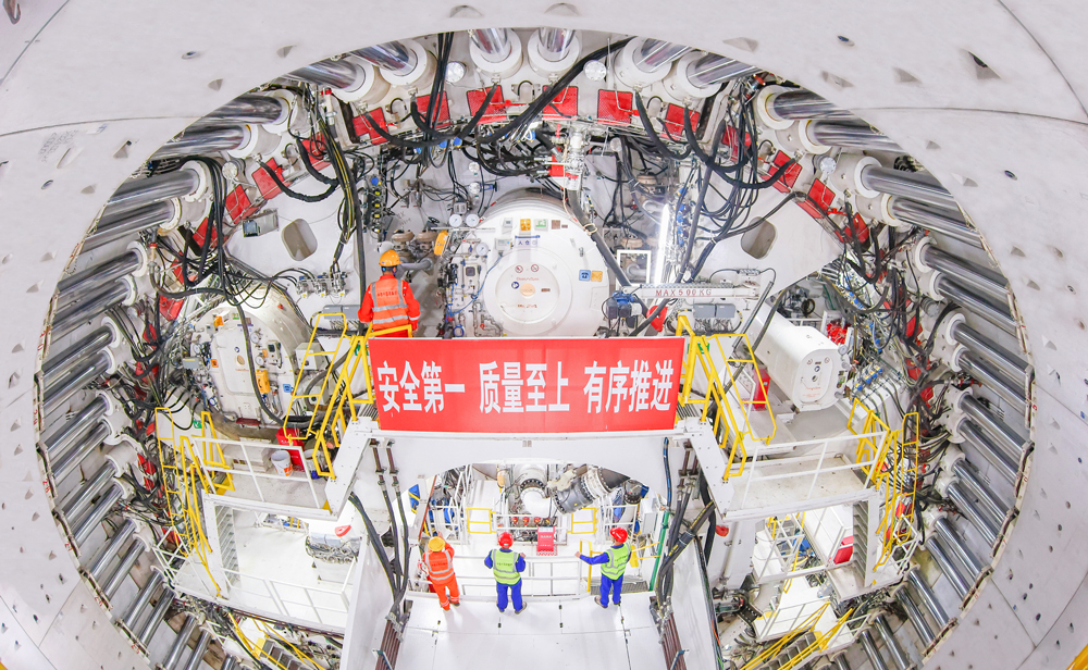 濟南市黃崗路穿黃隧道是濟南踐行“黃河流域生態(tài)保護和高質量發(fā)展”國家戰(zhàn)略的標桿性工程，工程南起藍翔中路，終點與在建G309互通立交相銜接，全長約5755米，雙向6車道，設計時速60公里，是世界最大直徑水下盾構隧道。施工中，隧道長距離穿越疊合地層，最深覆土厚度達49.2米，最大水土壓力6.3巴，先后下穿黃河兩岸大堤、黃河，掘進過程中沉降控制要求高，施工難度大。圖為盾構隧道內景。