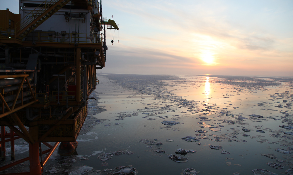 夕陽下的海冰和錦州20-2氣田平臺。