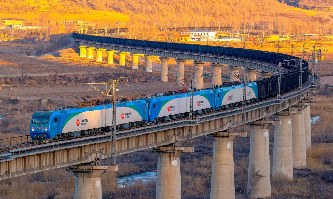 國家能源集團包神鐵路負責包神、神朔、甘泉、塔韓四條鐵路資產管理和生產運營，總營業里程872公里，專用線352公里，所轄的四條鐵路猶如四條鋼鐵巨龍，恰似黃河之弦，兩次橫跨黃河，途經內蒙古、陜西、山西沿黃河流域干支流，一路向東，直達渤海，承載著國家能源保供的重任，以其獨特的魅力和力量，為能源事業注入了源源不斷的活力。截至4月9日，包神鐵路年累計貨運量完成9035萬噸持續賦能能源保供。圖為包神鐵路神朔線一列萬噸列車飛速通過燕家塔大橋。