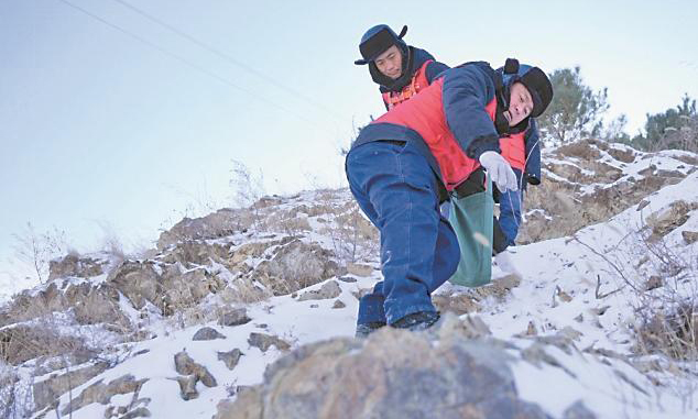 國家電網蒙東通遼奈曼旗供電公司工作人員巡檢10千伏青龍山線后相互攙扶下山。