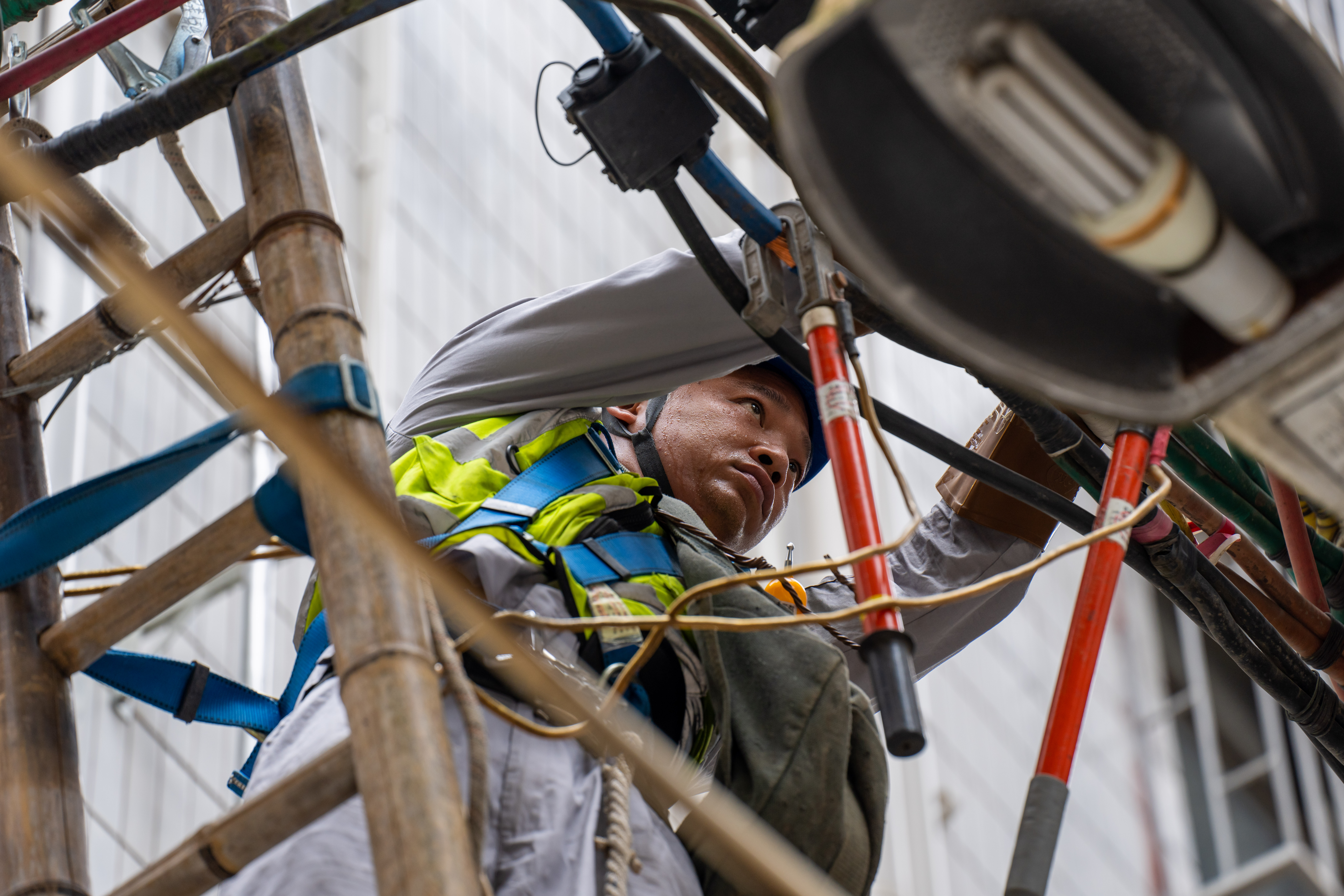 南方電網深圳龍崗供電局工作人員為城中村更換線路，迎接即將到來的夏季負荷高峰。黃志偉 攝.jpg