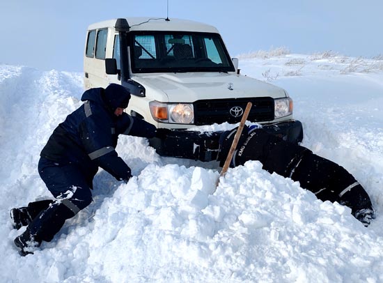 施工車輛在積雪路段被困，司機(jī)和查線工挖雪救車。.jpg