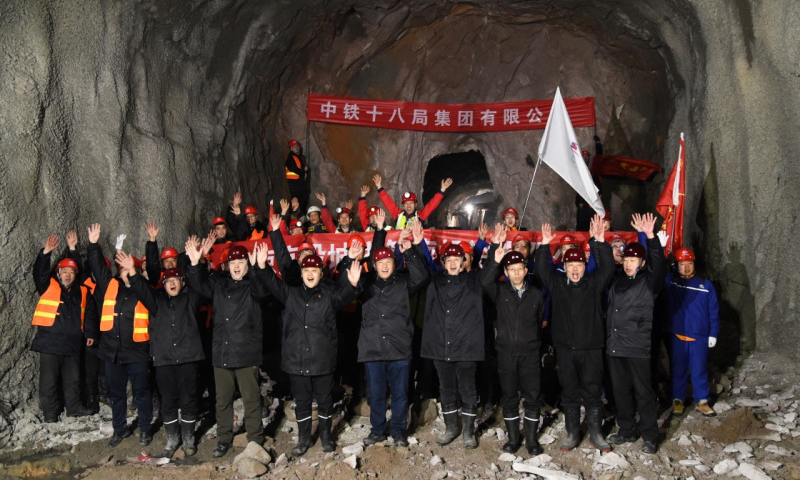 綜合管廊南起佛峪口水庫，北至延慶賽區(qū)核心區(qū)，為延慶賽區(qū)造雪用水、生活用水、再生水、電力、電信及有線電視等硬件接入提供通道。圖為1月7日，建設(shè)者們在管廊隧道貫通處慶祝。新華社發(fā)（任超 攝）