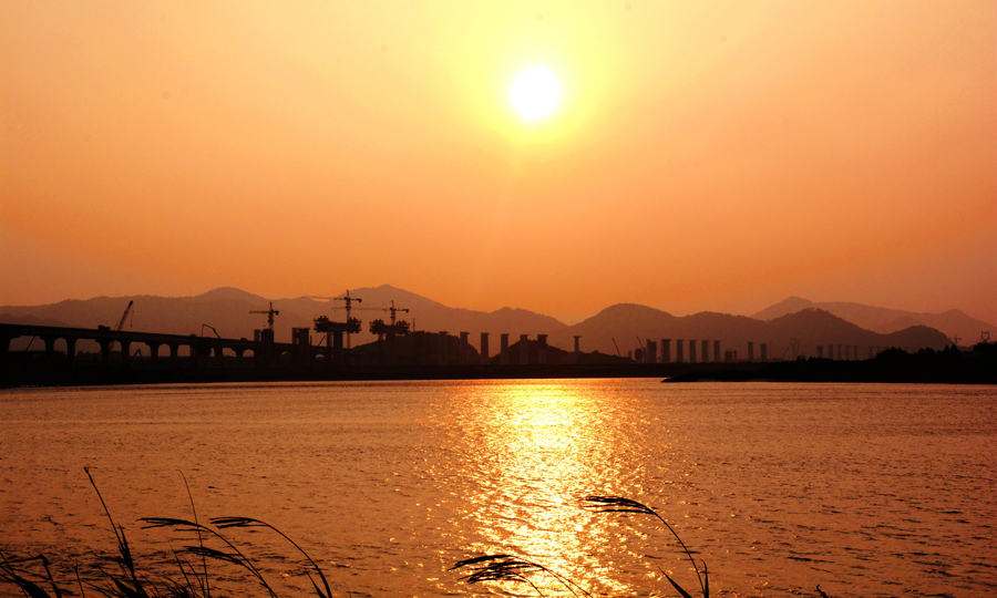 據(jù)悉，金臺鐵路是浙江省“大通道建設(shè)”的重點項目，是浙江省主導(dǎo)建設(shè)的第一條電氣化鐵路，對暢通浙江沿海及金臺沿線與浙中地區(qū)、皖贛及中西部地區(qū)的貨運交流、促進(jìn)沿線社會經(jīng)濟(jì)發(fā)展具有重要意義。金臺鐵路建成后，還將徹底結(jié)束浙江省仙居、磐安等縣無鐵路的歷史。圖為黃昏下的靈江特大橋。