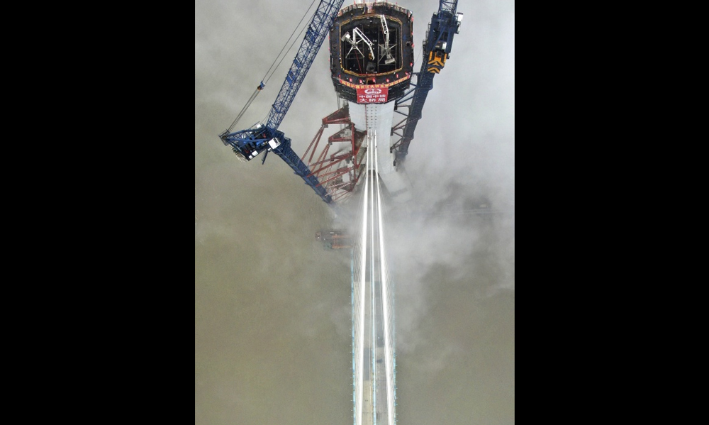 圖為6月26日，無人拍攝的滬通長江大橋南主塔封頂施工現(xiàn)場。（新華社記者 許叢軍 攝）