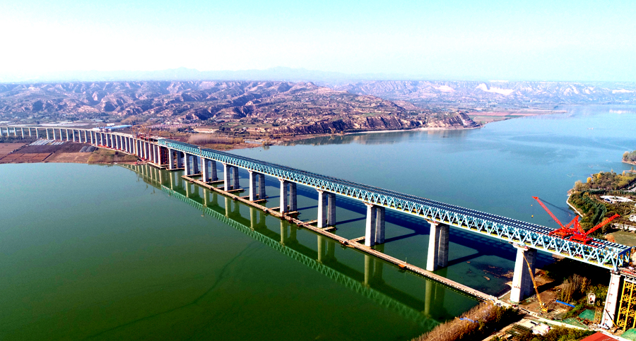 作為溝通“長江經濟帶”與“絲綢之路經濟帶”的重要干線，浩吉鐵路跨越數十條高速公路，穿越和連接20余條鐵路干線，第一次集疏運系統同步規劃和建設，銜接了沿線眾多煤炭基地和輸出入線路，豐富了這條能源大動脈的“毛細血管”，解決了鐵路運輸前后“一公里”難題。圖為中國鐵建大橋局承建浩吉鐵路三門峽黃河公鐵兩用大橋。