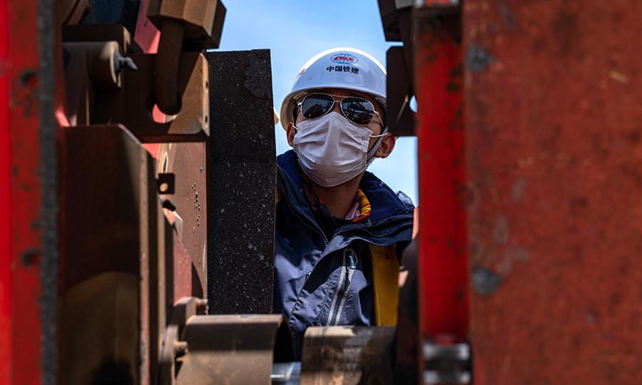 拉林鐵路無縫線路焊接的準備工作自2019年5月就已經開始。為了保證高原焊軌質量，該項目部嚴格按照國家標準，編制了《焊軌、放散首件工程施工工藝試驗》手冊，先后組織開展了工程線施工安全教育，焊軌、放散施工三級安全教育培訓，質量安全紅線管理規定宣貫學習以及焊軌、鎖定質量培訓。圖為技術人員正在調整焊軌機位置。（丁慶濱 攝）