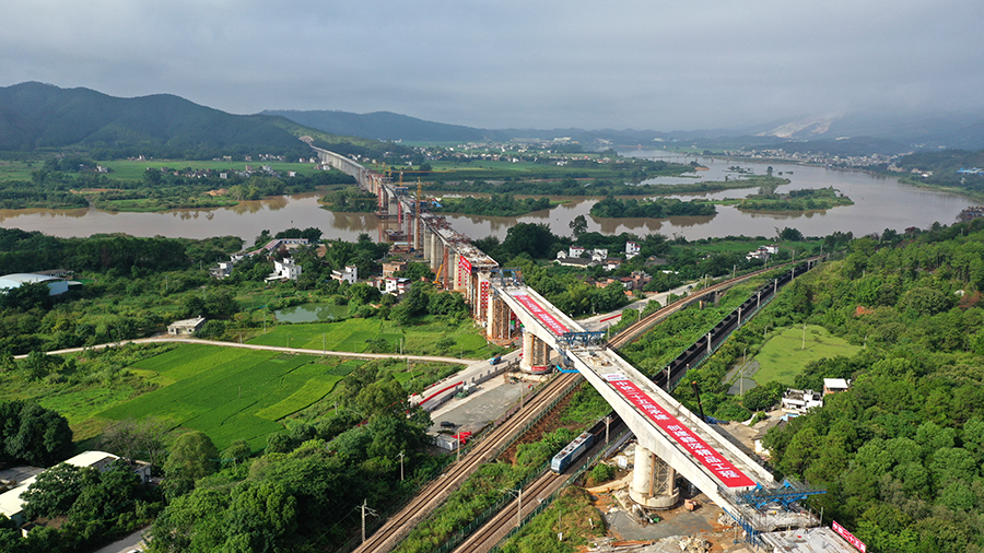 嶺南晨曦里，兩片巨型梁體在千斤頂?shù)睦瓌?dòng)下開(kāi)始逆時(shí)針旋轉(zhuǎn)，在施工過(guò)程中，中鐵二十五局技術(shù)人員布置轉(zhuǎn)體裝置，實(shí)時(shí)動(dòng)態(tài)監(jiān)控動(dòng)力系統(tǒng)運(yùn)行情況、轉(zhuǎn)盤(pán)轉(zhuǎn)過(guò)的刻度，每轉(zhuǎn)5度報(bào)告轉(zhuǎn)體進(jìn)度、應(yīng)力變化等情況。圖為橋梁完成轉(zhuǎn)體精準(zhǔn)對(duì)接。（陳浩 攝）