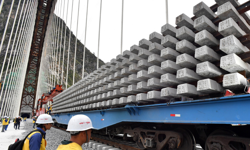 藏木特大橋位于西藏山南市加查縣境內，全長525.1米，主拱跨徑430米，橫跨雅魯藏布江。圖為9月20日，中鐵十一局工程技術人員在藏木特大橋上鋪軌。（新華社記者 覺果 攝）