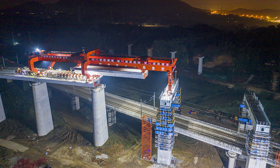 常益長高鐵正線全長約157公里，設計時速為350公里，是國家“八縱八橫”高速鐵路網(wǎng)的重要組成部分，是形成湖南省高鐵環(huán)線的關(guān)鍵組成部分。建成通車后，將實現(xiàn)湖南全省14個市州全部通高鐵的目標。圖為作業(yè)人員正在架設箱梁。（彭特 攝）