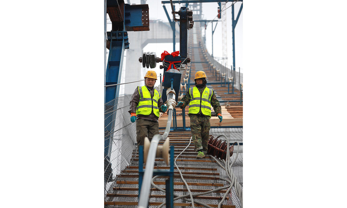 圖為1月5日，建設者們在開州湖特大橋建設工地進行主纜索股架設。（新華社記者 劉續 攝）