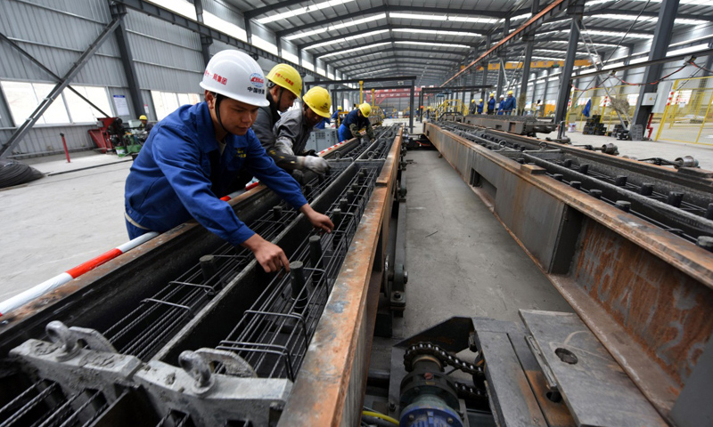 承擔拉林鐵路全線鋪軌任務的中鐵十一局建設者，克服高原缺氧、施工條件復雜等困難，為9月開始的鋪軌工作做準備。圖為7月16日，在中鐵十一局橋梁公司曲水制枕場生產車間，技術人員在進行軌枕箍筋作業。（新華社記者 宋振平 攝）